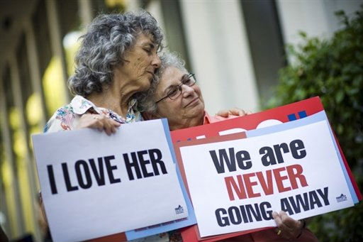 Lesbian couple with pro-marriage equality signs